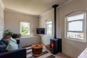 a living room with a stove and a couch at Auberge Burgundy Boutique Hotel & Spa in Hermanus