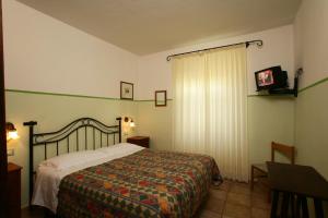 a bedroom with a bed and a television in it at Le Camere Di Paolino in Manciano +12 photos