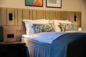 Schlafzimmer mit einem Bett mit weißer Bettwäsche und Kissen in der Unterkunft Quality Hotel Prinsen in Trondheim