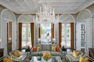 a living room with a couch and a chandelier at Mandarin Oriental, Bangkok in Bangkok