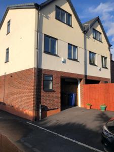 a house with a garage and a fence at M60 Modern Studio Appartment with free parking in Denton