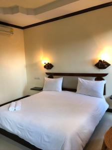 a bedroom with a large white bed with two pillows at Siwasom Resort Sakon Nakhon in Sakon Nakhon
