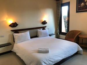a bedroom with a large white bed with a window at Siwasom Resort Sakon Nakhon in Sakon Nakhon