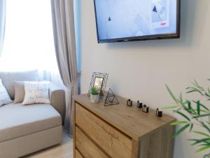 uma sala de estar com uma televisão e uma mesa de madeira em Studio Suite near Lake with Jacuzzi em Sumy