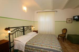 a bedroom with a bed and a chair at Le Camere Di Paolino in Manciano