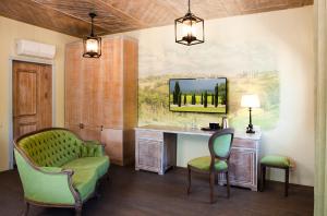 カリーニングラードにあるVilla Toscanaのデスク、椅子2脚、鏡が備わる客室です。