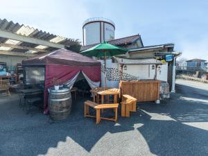 a patio area with chairs, tables and umbrellas at Tabist Hotel Nizi Fuefuki Misaka in Fuefuki