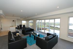 a living room with black leather furniture and a blue rug at Niagara Ridge Retreat Catlins in Niagara
