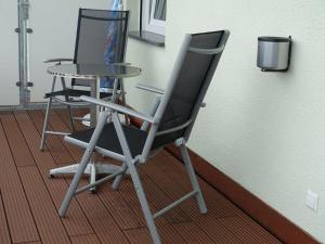 einen Stuhl und einen Tisch neben einer Wand in der Unterkunft Hotel Gasthaus Krone in Immenstaad am Bodensee