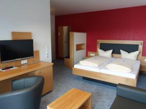 Schlafzimmer mit einem Bett und einem Flachbild-TV in der Unterkunft Hotel Gasthaus Krone in Immenstaad am Bodensee