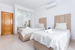 1 dormitorio con 2 camas y espejo en Newly refurbished townhouse, en Budens