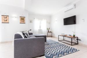 sala de estar con sofá y TV en Newly refurbished townhouse, en Budens