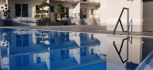 a swimming pool in front of a house with its reflection in the water at Gartenhotel Heusser in Bad Dürkheim