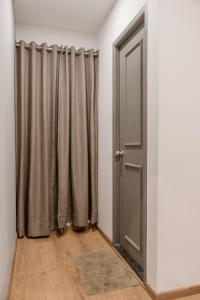 um quarto com cortinas cinzentas e uma porta em Madras Regency em Chennai