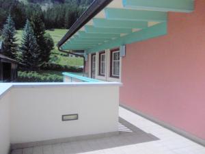 a side view of a house with a blue roof at La Meisules in Pozza di Fassa