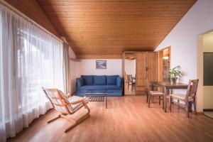 a living room with a blue couch and a table at Central Wengen Wonderland: Mezzanine Studio for 4 in Wengen +5 photos