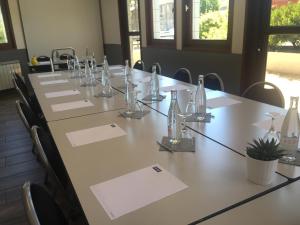 a conference room with a long table with glasses on it at Kyriad Saint-Etienne Centre in Saint-Étienne