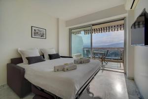 um quarto com uma cama grande e uma janela grande em IMMOGROOM- Magnificent View - NEW - Terrace - AC em Cannes