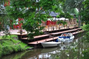 two boats are docked at a dock on a river at Bootshaus in Bedekaspel