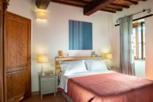 a bedroom with a large bed with a red blanket at La Fattoria del Rio di Sopra - Agriturismo Baldeschi in Tuoro sul Trasimeno