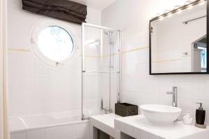 un bagno bianco con lavandino e specchio di La Villa Blanche - 18 personnes a Pénestin Altre 22 foto