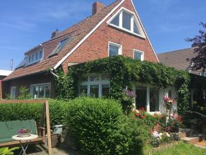 a brick house with ivy on the side of it at Ferienhaus Blumenmeer in Norderney