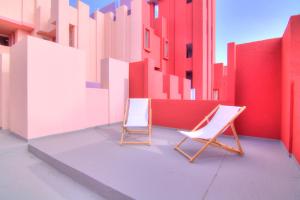 two chairs sitting next to each other in front of a building at Studio in the Red Wall building by Ricardo Bofill - MURALLA ROJA in Calpe