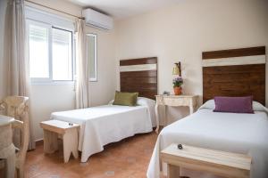Un dormitorio con dos camas y una ventana. en Puerta de Algadir, en El Puerto de Santa María
