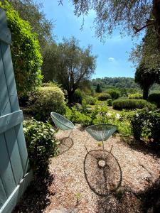 dos sillas de metal sentadas en el suelo en un jardín en Le Manoir de L'Étang, en Mougins