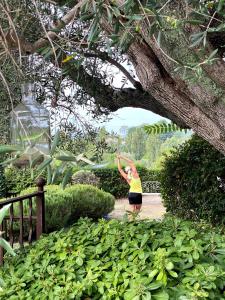 a woman standing in a garden under a tree at Le Manoir de L'Étang in Mougins