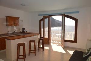 a kitchen with a counter and a view of the ocean at Sunset in the Atlantic Apartamentos Playa de Alojera in Vallehermoso