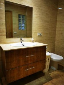 a bathroom with a sink and a toilet and a mirror at A Casa de Matelos in A Lanzada