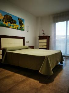 a bedroom with a bed and a dresser and a window at A Casa de Matelos in A Lanzada