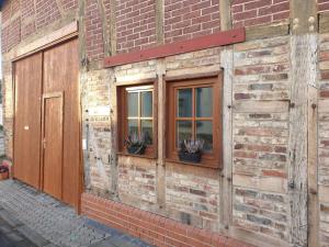 - un bâtiment en briques avec deux fenêtres et une porte dans l'établissement Düx-Hof Apartment Fachwerkhaus, à Bornheim