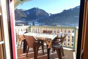 uma mesa e cadeiras numa varanda com vista em La Meisules em Pozza di Fassa