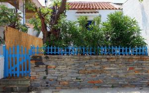 une clôture bleue devant une maison dans l'établissement Small traditiional home near the shops and restaurants in Korissia, Kea, à Ioulída