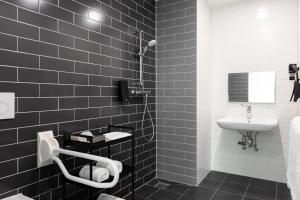a black and white bathroom with a sink and a shower at Holiday Inn Express Amsterdam - North Riverside by IHG in Amsterdam