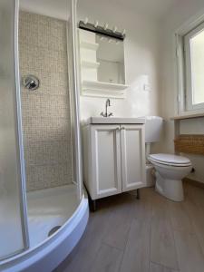 une salle de bain avec toilettes, lavabo et douche dans l'établissement Casa Genepy - monolocale in centro a Sestriere, à Sestrières