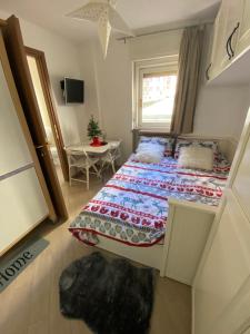 a small bedroom with a bed and a window at Casa Genepy - monolocale in centro a Sestriere in Sestriere