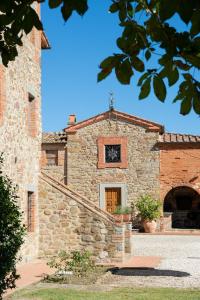 eine Außenansicht eines Steingebäudes mit einer Tür in der Unterkunft La Fattoria del Rio di Sopra - Agriturismo Baldeschi in Tuoro sul Trasimeno