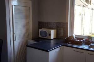 una cocina con microondas en una encimera en Zara Apartments, en Dundee 22 fotos más