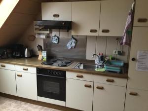 a kitchen with a stove and a sink at Ferienwohnung Familie Heigemeir in Ehekirchen
