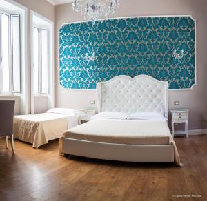 a bedroom with two beds and a blue wall at Opera Relais in Messina