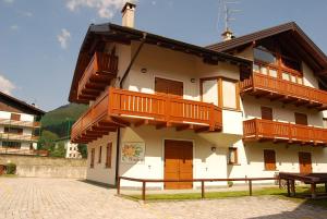 a building with wooden balconies on the side of it at Trilocale Carisolo 014 in Carisolo