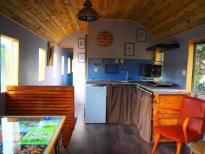 a kitchen with a white refrigerator and a table at La Gare De Millas Chambres d'hôtes in Millas