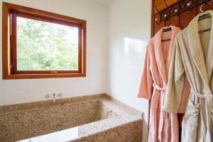 a bathroom with a large tub and a window at Magnificat Cottage in Cunha +84 photos