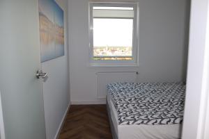 een kleine slaapkamer met een bed en een raam bij Apartamenty Asapartment Stockholm in Olsztyn