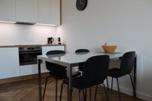 een keuken met een tafel en 4 stoelen bij Apartamenty Asapartment Stockholm in Olsztyn