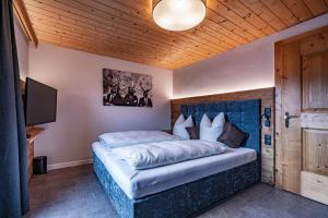 ein Schlafzimmer mit einem großen Bett und einer Holzdecke in der Unterkunft Alpin View in Zellberg