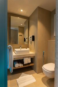 a bathroom with a sink and a toilet and a mirror at Holiday Inn Express & Suites Bengaluru Old Madras Road, an IHG Hotel in Bangalore